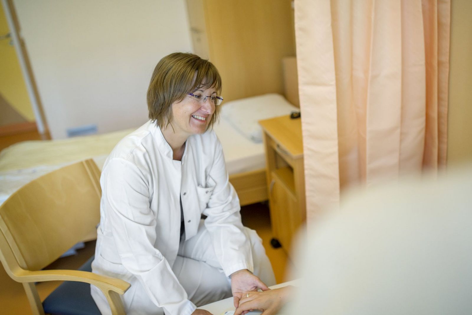 Die zuständige Oberärztin Dr. med. Tanja Thormann besucht einen Patienten im Palliativzimmer